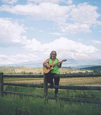 Gabriel of Urantia posing with guitar in front of Mt. Shasta before concert